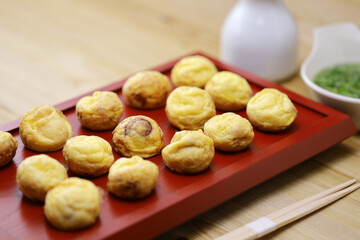 Homemade Akashiyaki (the origin of takoyaki) is round dumplings made of an egg-rich batter and octopus. Dipped into dashi before eating. Japanese food.