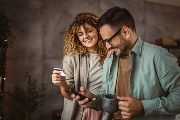 wife hold credit card and cup buy online with husband on cellphone