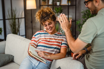 girlfriend sit on sofa read book and discuss whit her boyfriend