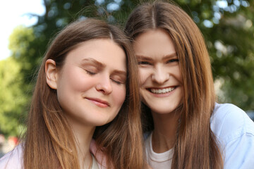 Fototapeta premium Portrait of two beautiful twin sisters outdoors