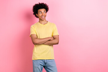 Portrait of nice young man crossed hands look empty space wear yellow t-shirt isolated on pink color background