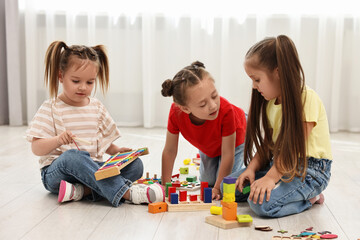 Naklejka premium Cute little children playing together on floor indoors