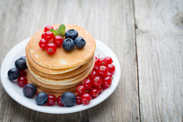 Stack of pancakes with blueberry and fresh berry.