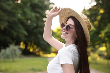 Portrait of smiling woman in hat outdoors, space for text. Spring vibes