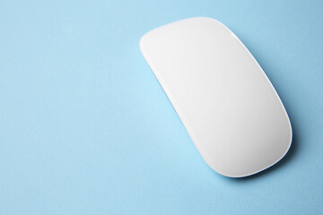 One wireless mouse on light blue background. Space for text
