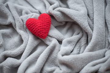 Red heart in gray background. Love concept. Knitted yarn heart on cover in valentine day. Healthcare idea.