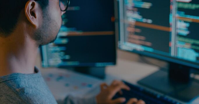 Closeup young adult Asia male freelance typing write prompt AI bot IT app smart program nomad, video game, terminal with coding language, designer, big data center on desktop computer in night office.