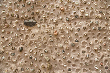 House wall with pebble stones and filled with cement, seen in Sardinia, Italy-Natural stone texture for architecture, garden design, landscaping or environmentally sustainable engineering