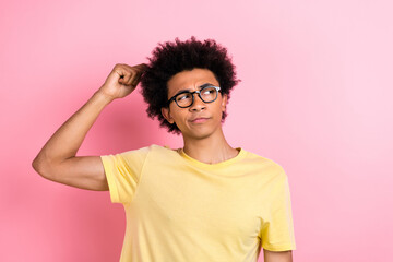 Photo of minded creative handsome man arm fingers scratch head look empty space isolated on pink color background