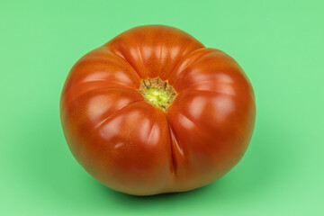 grosse tomate, en gros plan, sur un fond vert