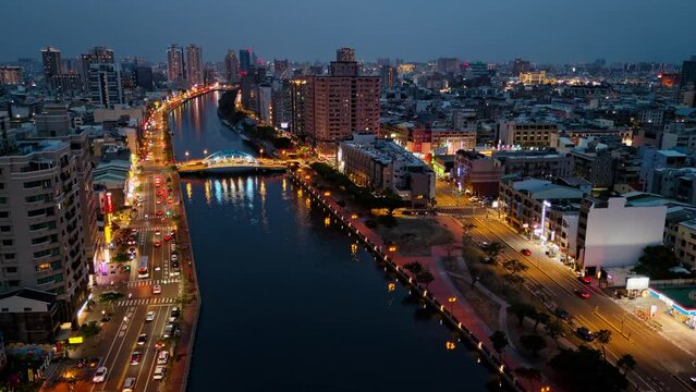 HYPERLAPSE_Night skyline of high-rise riverside buildings in Anping District, Tainan City, Taiwan, with a cable stayed bridge across the canal and city lights dazzling under blue twilight sky0001_121