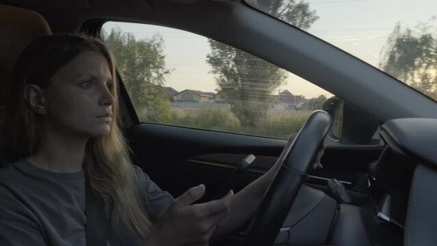 Woman using mobile smart phone while driving car