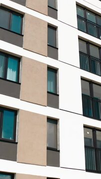 Apartment blocks with balconies. Stock footage. Aerial view of an apartment building on a blue cloudy sky background.