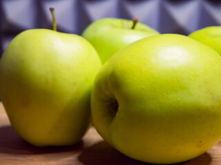 Apples on a wooden table, freshness emphasized.