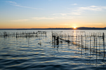 Beautiful view of the lagoon at sunset with fishing nets in Valencia, Spain © Chris DoAl