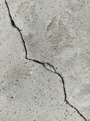 One diagonal uneven crack in a rough concrete surface. An old ruined, cracked,  cement wall of a building. Destruction after earthquake. Copy space. Repair, construction of buildings