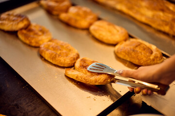 Close-up photo of a freshly baked pastry, at the bakery, focus on the cheesy pastry.