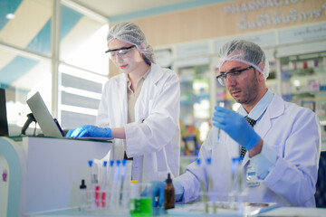 Fototapeta premium scientists perform experiments and record data. people arranges equipment with test tubes and chemicals for producing medicine and biochemistry. man hold tubes of chemical liquids and plant samples.