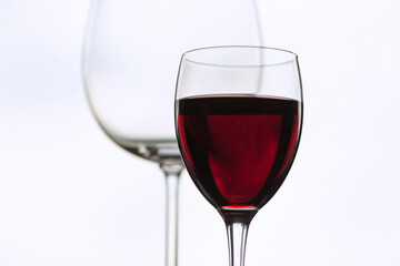 Kryształowe kieliszki, czerwone wino, białe tło. Tapeta, dekoracja. 