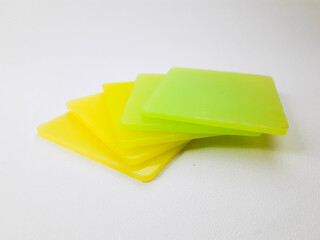 stack of graded yellow and green color chips, isolated on a white background. This is an example of the color produced by masterbatch in plastic products