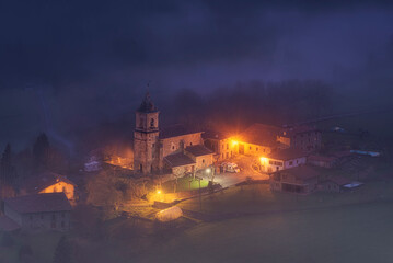 Obraz premium Ibarra Church in Aramaio, Alaba, shrouded in fog moments before dawn