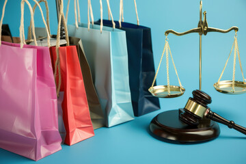 Gavel, judge scale and shopping bags on background with copy space , symbolizing online shopping, e-commerce laws, and consumer rights in a digital marketplace.