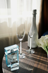 The letters Y and J are the initials of the newlyweds. A composition of a bottle of champagne, glasses, a bouquet and a case with wedding rings is laid out on the table.