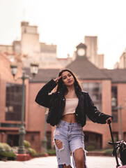 Stylish travel: vibrant young latina brunette with fashion look and pink suitcase exploring city downtown