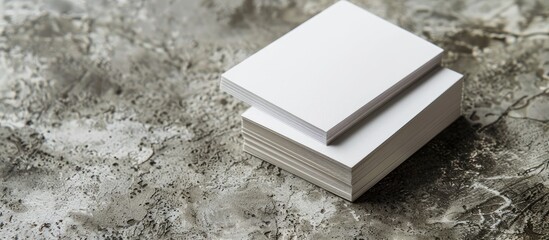 Two stacks of blank paper business cards displayed on a textured background, providing copy space image.