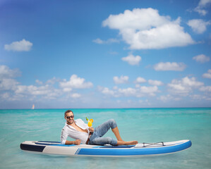 Fototapeta premium Guy sitting on a SUP in the sea