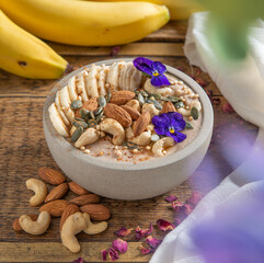 Smoothie bowl with, muesli, fruits and nuts. Healthy concept. Rustic background.