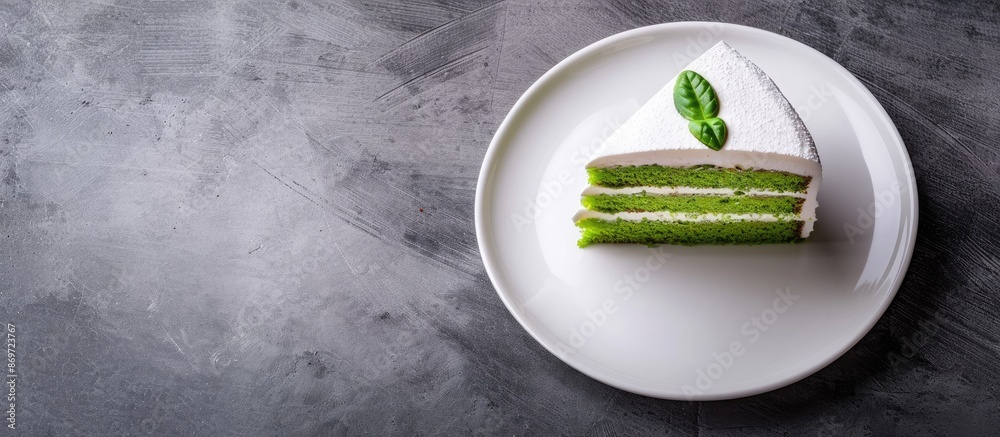 Poster green pandan sponge cake displayed on a white plate with copy space image.