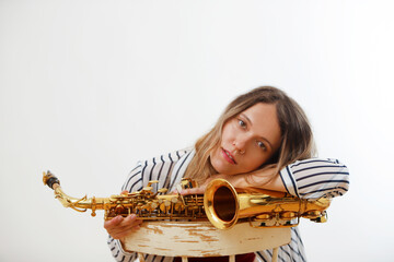 female saxophonist resting on saxophone looking into camera