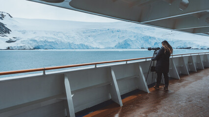 Antarctica Cruise Female Photographer Travel Blogger Influencer Sets Up Glacier Shot Over Side Hand Railing. On Tripod Professional Telephoto © And They Travel