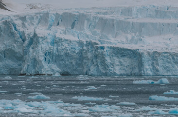 Climate Change Icebergs Floating and Melting Near Wall of Breaking Ice Glacier Antarctica. Global Warming South Pole Remote Nature Background