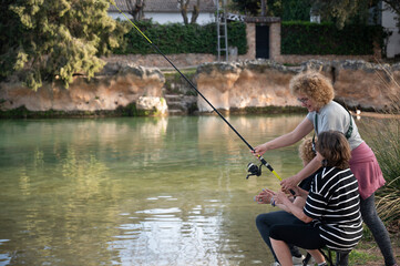 Middle-aged women learning to fish together at a tranquil pond.