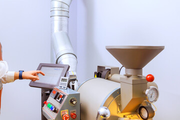 In roasting machine, raw coffee beans are baked