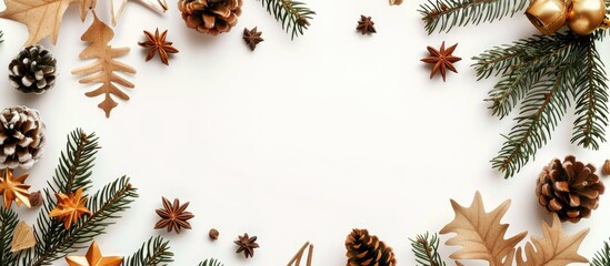 Naklejka premium Flat lay top view of a Christmas frame adorned with gold decorations like pine cones, star anise, and spruce branches on a white background with room for text or images.