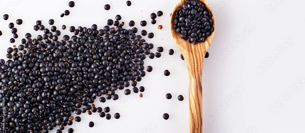 Poster black lentils beans with a wooden spoon against a white backdrop with room for text or other element