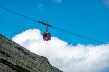 Obraz premium Alpine cable car with tourists heading to Lomnicky štít Slovakia