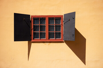 A yellow wall with a window