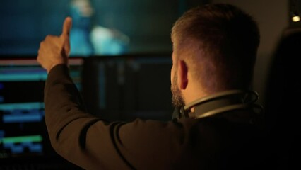 Male studio engineer showing OK symbol to woman singer in recording studio. Professional musicians working together in modern record label, creating new single for music album, talented people team