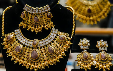 gold necklace and earrings set on display in a store heavy gold jewellery elaborate gold jewelry.