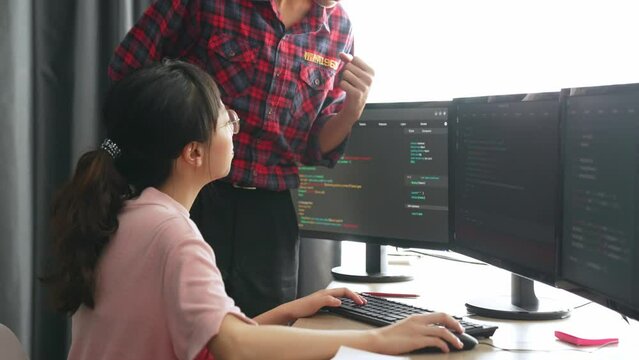 Slow motion back end or software developer manager supervising his team on new application program development on debugging and solving complex code algorithms on monitor. Burgeoning