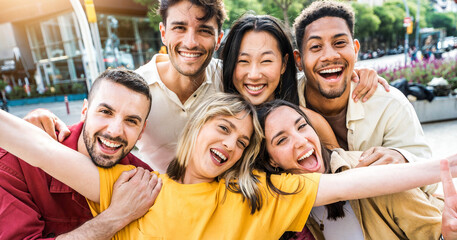 Multi ethnic young people smiling together at camera outdoors - Happy group of friends having fun...