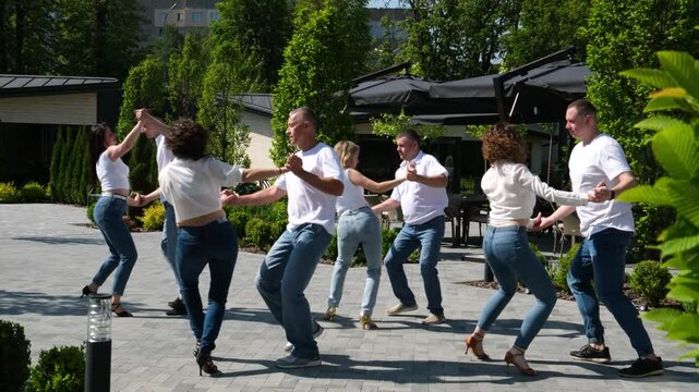 Bachata in the park. Open air latina dance party. Sunset with pink sky. People dancing bachata in the park. Fun and positive atmosphere.