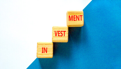 Investment symbol. Concept word Investment on beautiful wooden blocks. Beautiful blue and white background. Business investment concept. Copy space.