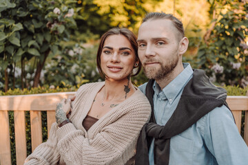 Happy loving couple enjoying their time together in park. Loving couple spending time together. Girl with tattoos. Tattooed man.