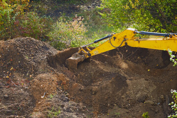 Captured in detail, the excavator's bucket shows the wear and tear of continuous, heavy-duty digging