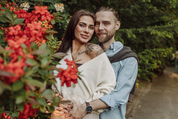 Obraz premium Young fun surprised couple family man woman in rest relax together boyfriend meet girlfriend. Close-up portrait of a girl with a freckled face standing and hugging his neck in the sunlight.